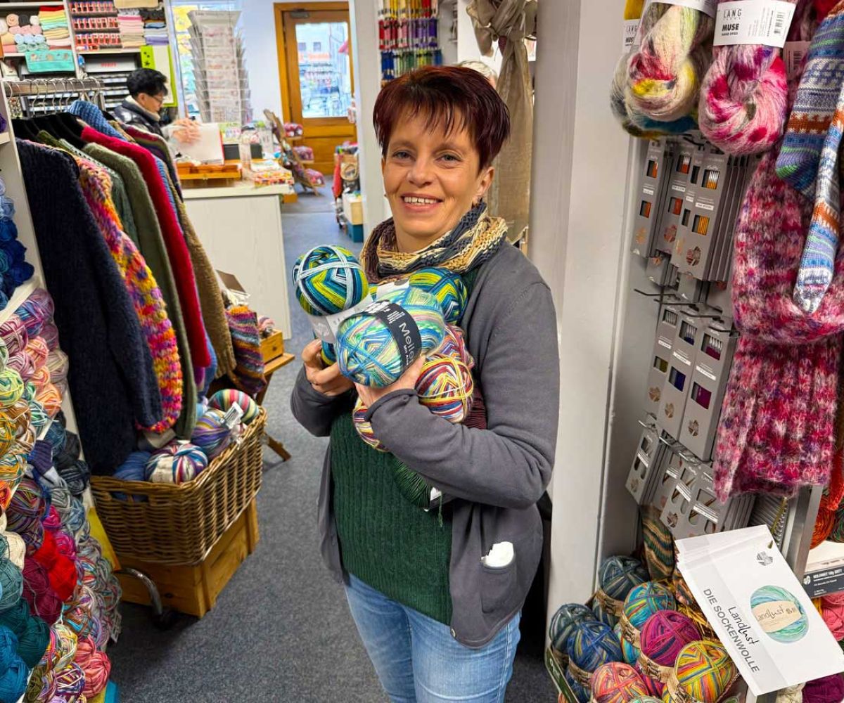 Annika stehend im Laden mit Knaeuel Sockenwolle